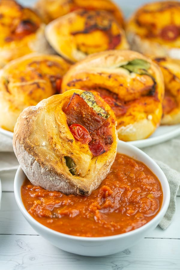 homemade pizza roll dipped in a bowl of tomato sauce