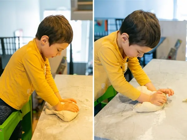 5 year old kneading dough to make pizza rolls