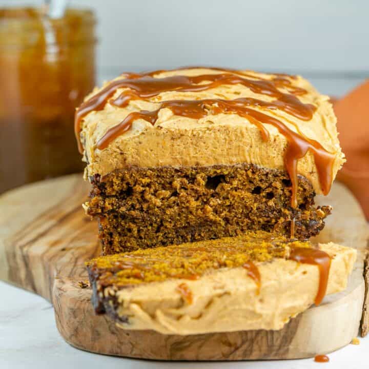 loaf of pumpkin bread with pumpkin buttercream frosting and salted caramel drizzle