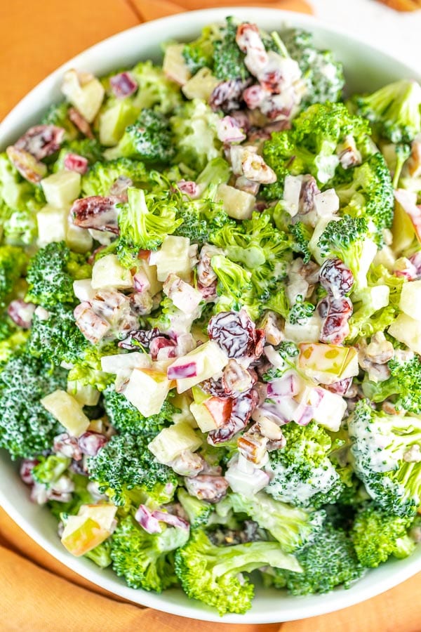 large bowl of broccoli salad with pecans, apples, cranberries, and pomegranate