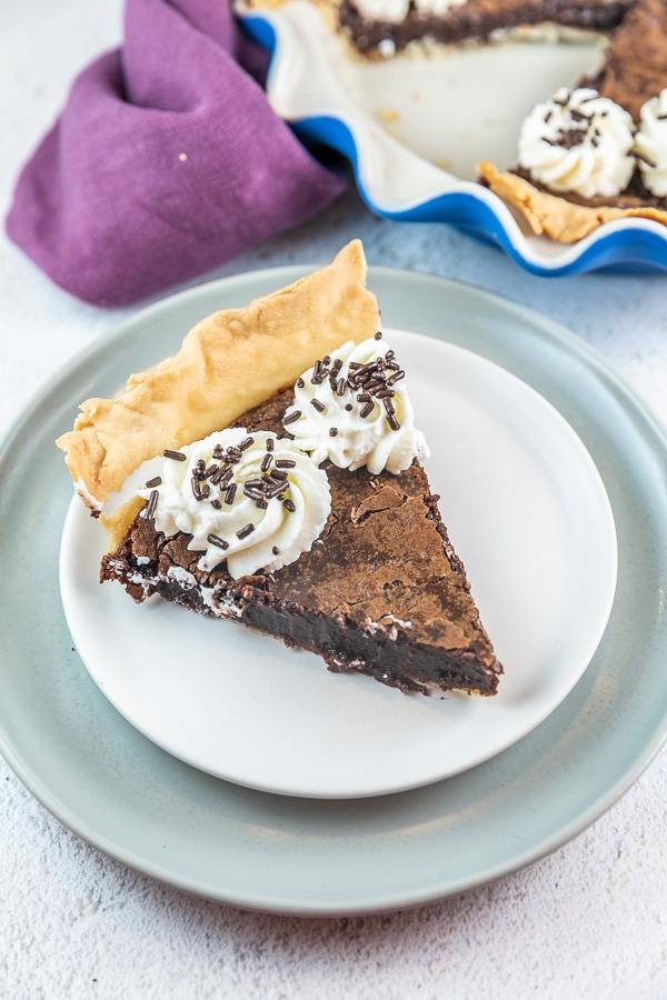 large slice of brownie pie with whipped cream and chocolate sprinkles