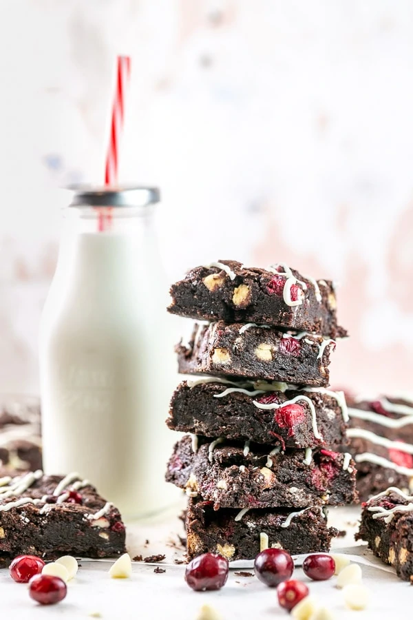 stack of brownies with a glass of milk in the background