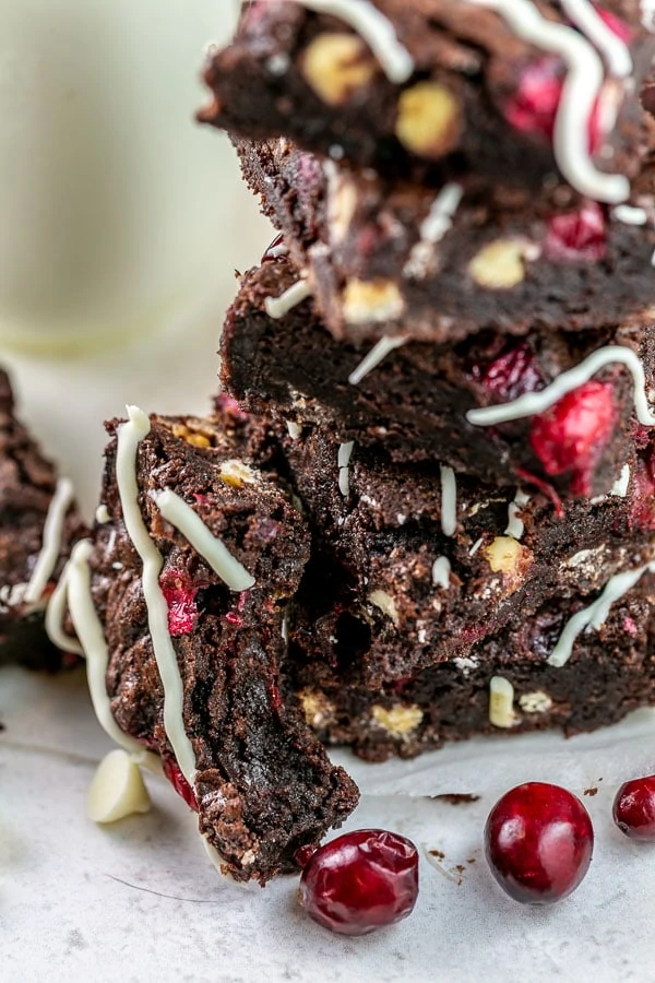 stack of brownies with a bite taken out of one showing the rich fudgy interior.