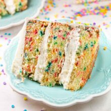 slice of three layer funfetti cake covered in sprinkles