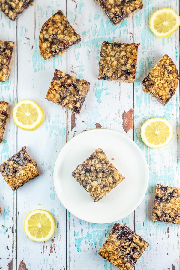 oatmeal jam bars with lemon slices on a blue and white wooden table
