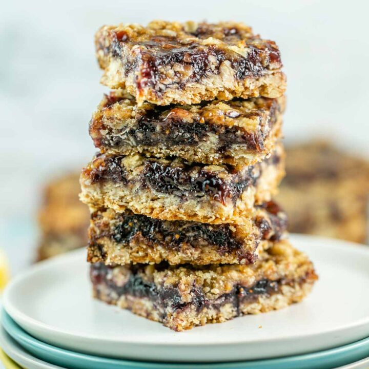 stack of dessert bars filled with jam on small plates