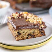 slice of banana chocolate chip cake with nutella frosting and chopped hazelnuts