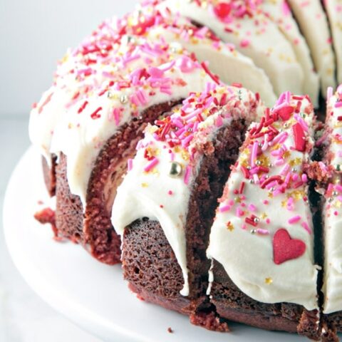 slices of red velvet bundt cake with frosting and pink sprinkles
