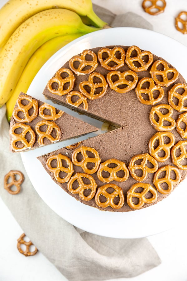 one wedge cut out and partially removed from a pie covered with pretzels on top