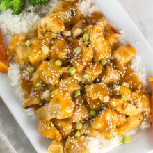 pile of orange chicken on top of a layer of steamed rice