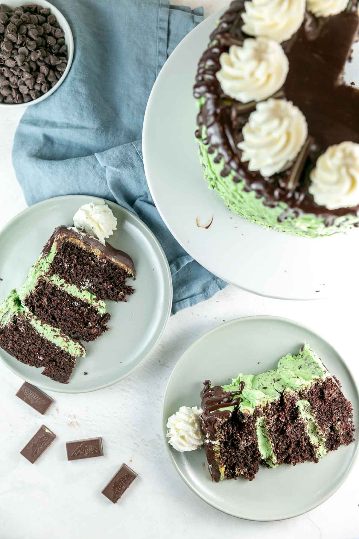 overhead view of two slices of cake on dessert plates with Andes mints scattered in the background