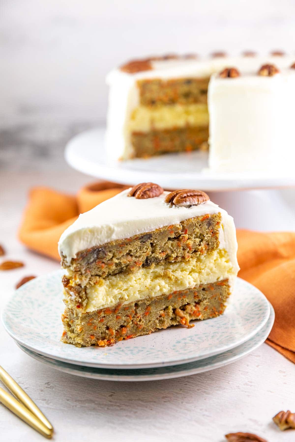 a slice of a cake with two layers of carrot cake and one layer of cheesecake