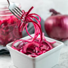 thinly slice pickled red onions on a fork