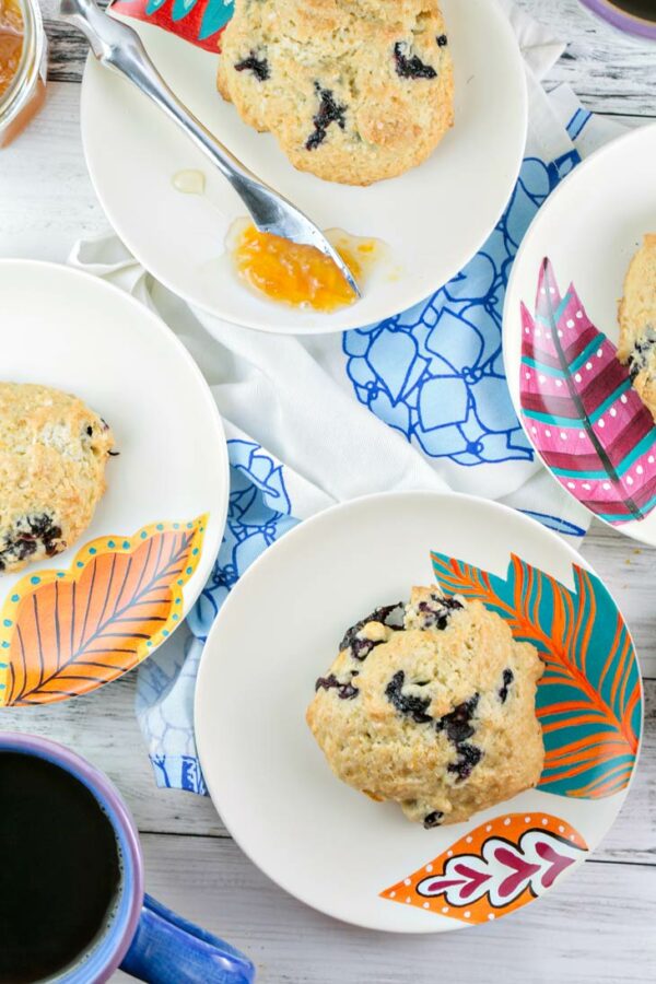 scones filled with lemon zest and blueberries next to cups of coffee
