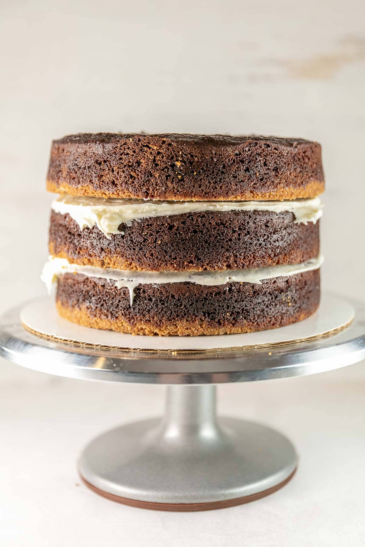 three layers of chocolate graham cracker cake stacked before frosting