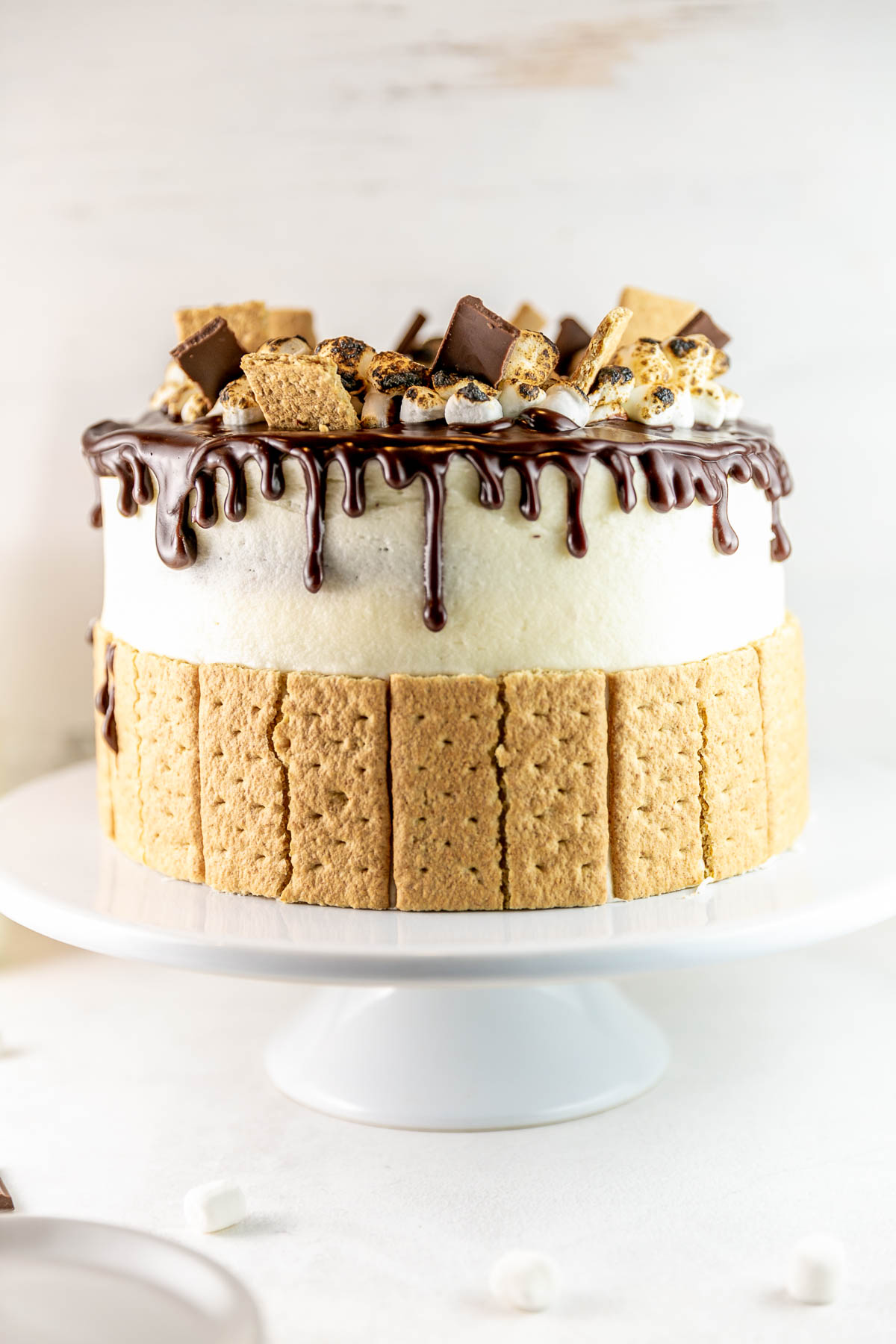 three layer s'mores cake decorated with graham crackers and toasted marshmallows