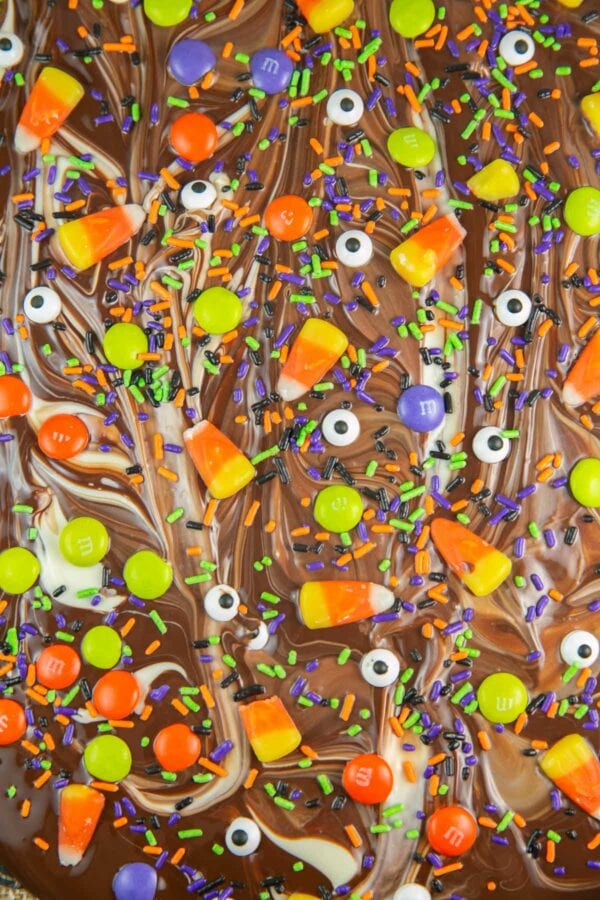 close up picture of white and dark chocolate swirls covered with Halloween candy toppings