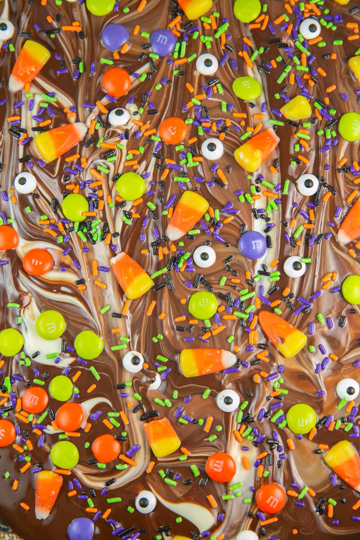 close up picture of white and dark chocolate swirls covered with Halloween candy toppings.