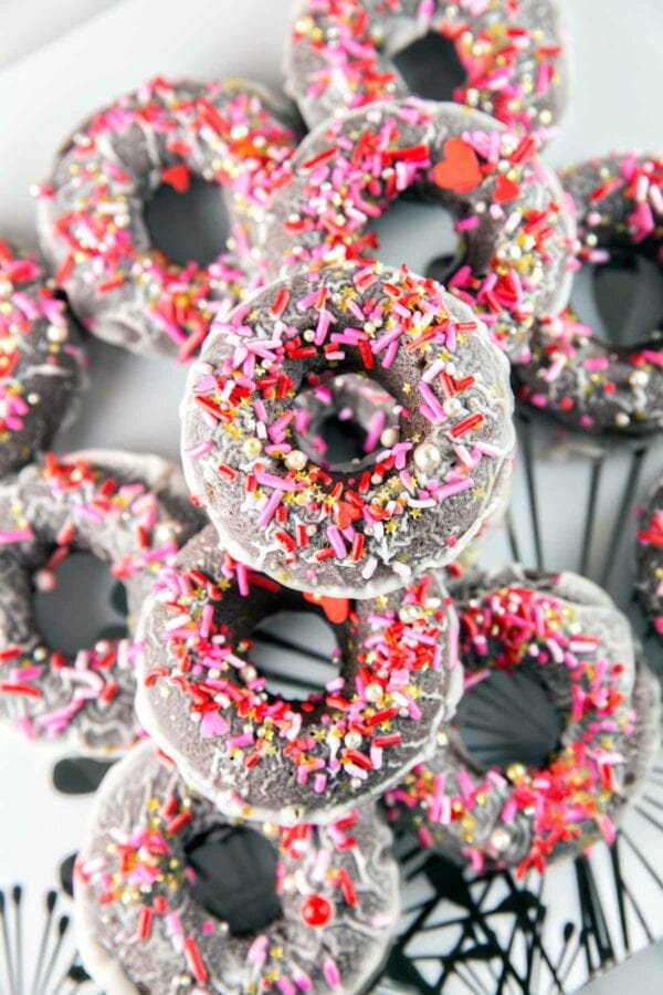 pile of baked peppermint mocha donuts covered in festive sprinkles