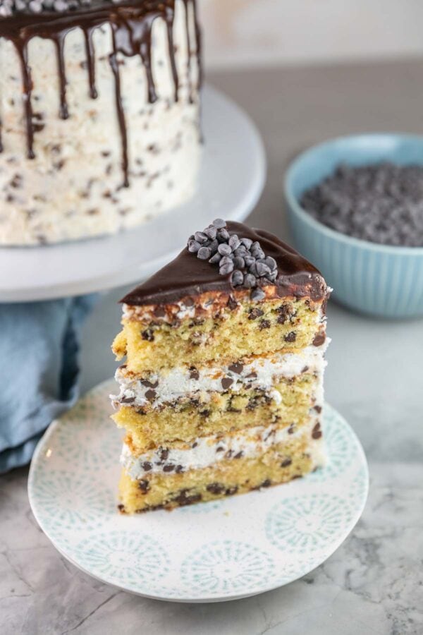 slice of three layer white cake with chocolate chips on a dessert plate