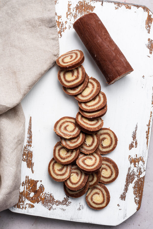 roll of slice and bake pinwheel cookie dough with sliced unbaked cookies
