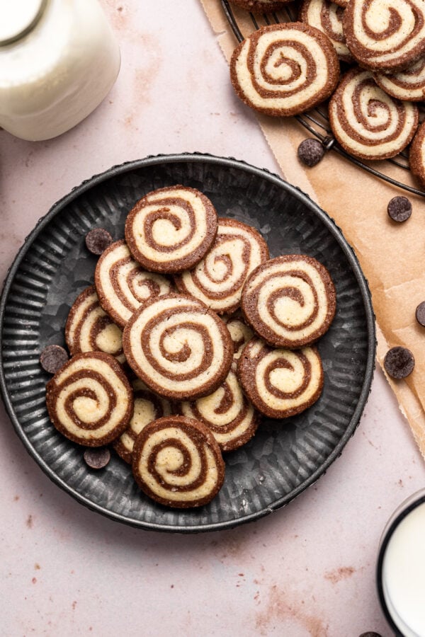chocolate and vanilla spiraled cookies on a textured black plate