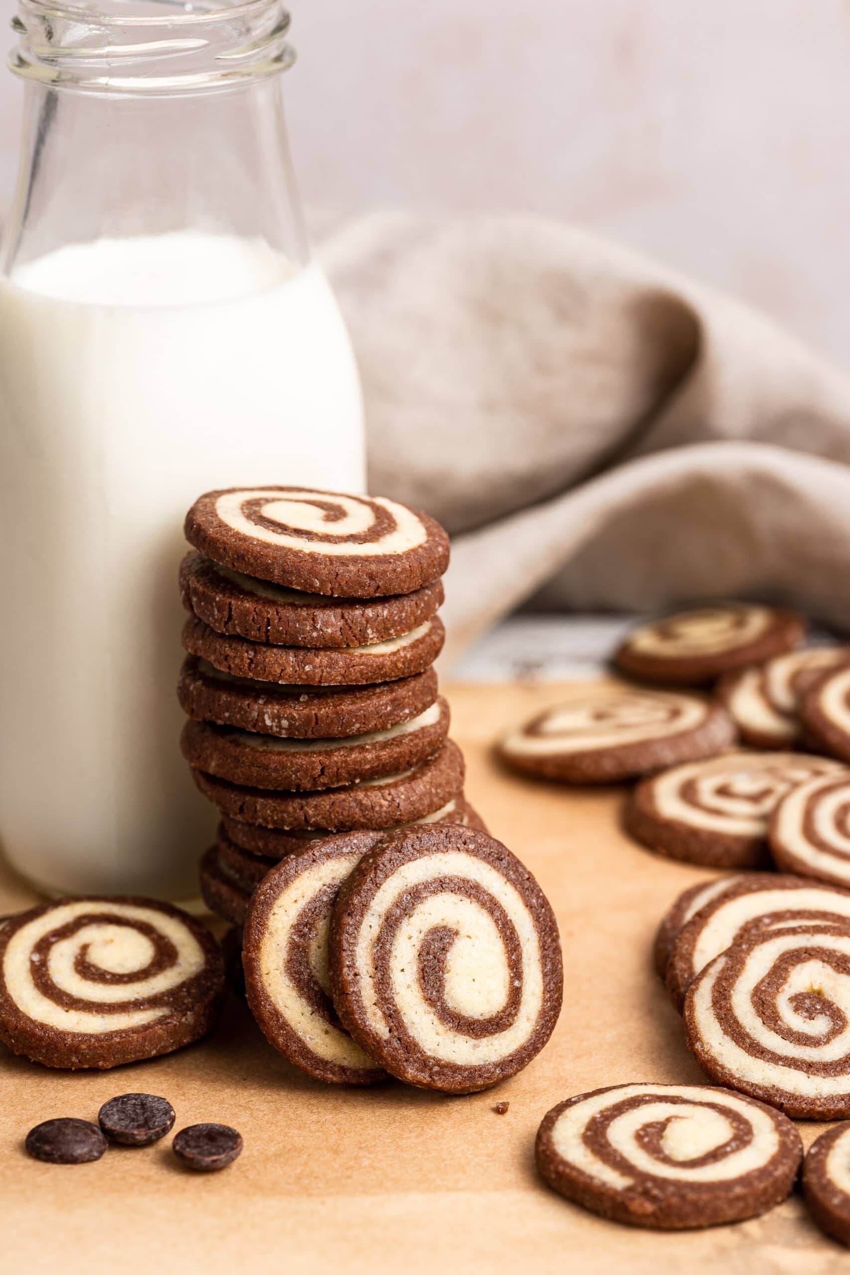 stack of cookies in front of a jug of milk