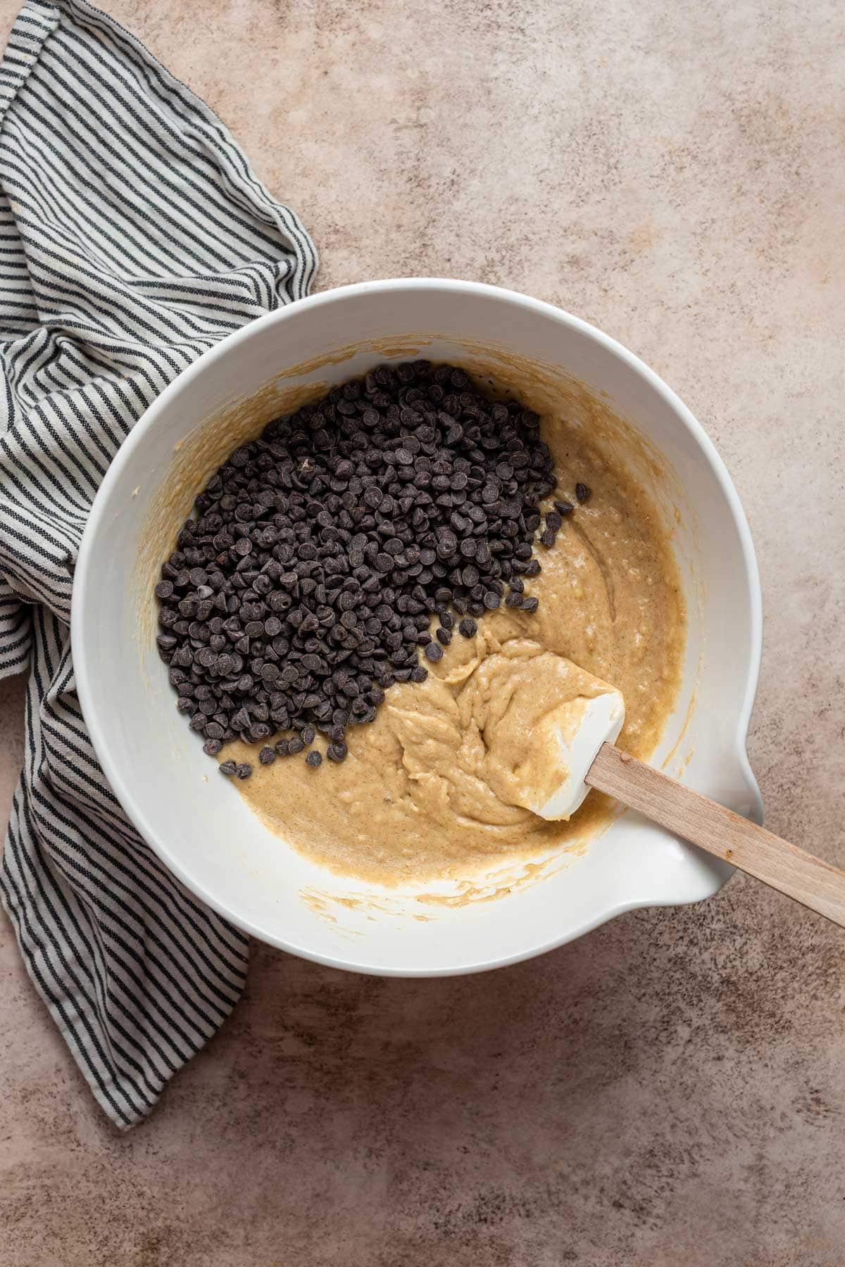 mixing bowl filled with muffin batter and miniature chocolate chips