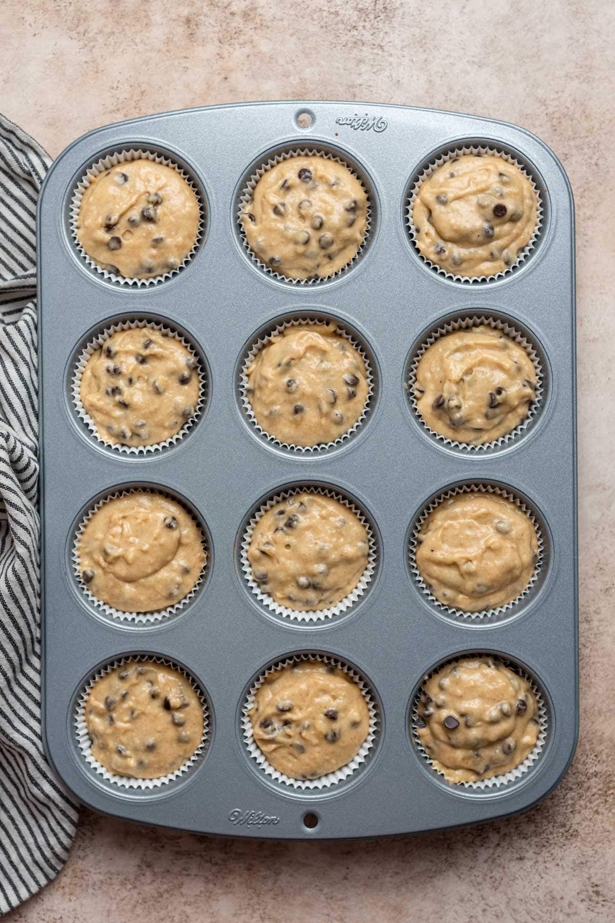 banana bread muffin batter in a muffin tin before baking.