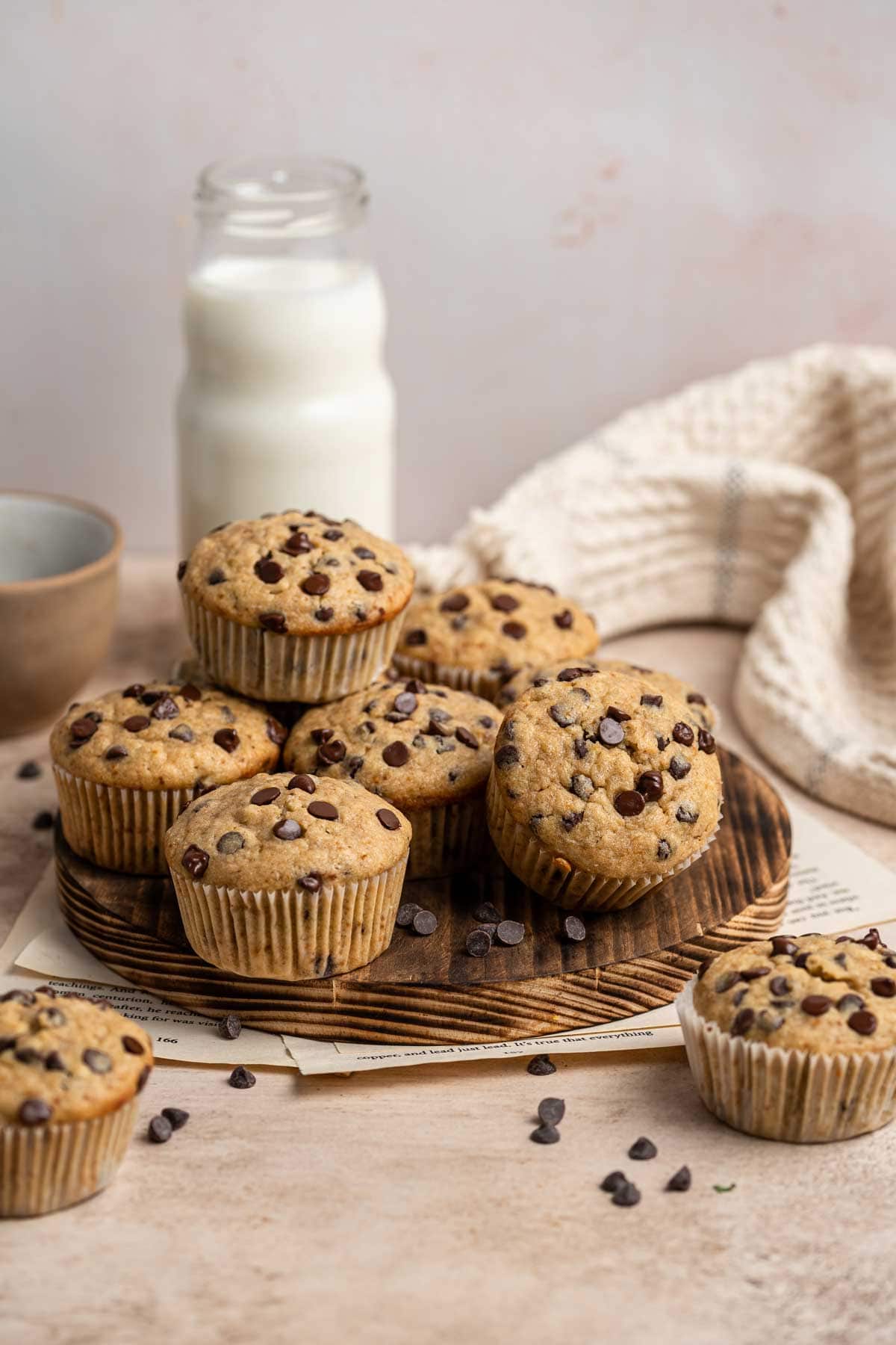 stack of banana bread muffins on a round wooden cutting board.