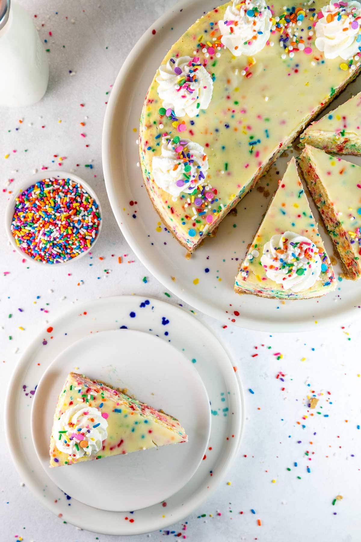 a slice of cake batter cheesecake on a small plate next to additional slices of cheesecake