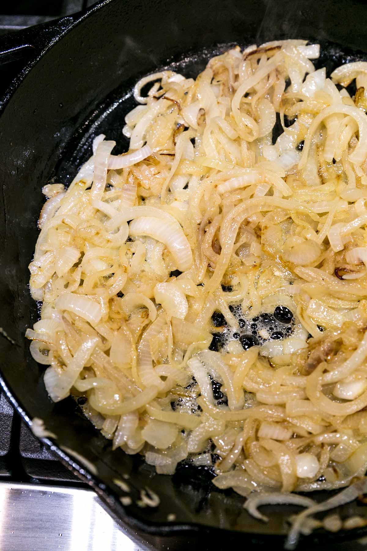 caramelized onions in a cast iron skillet just starting to turn golden
