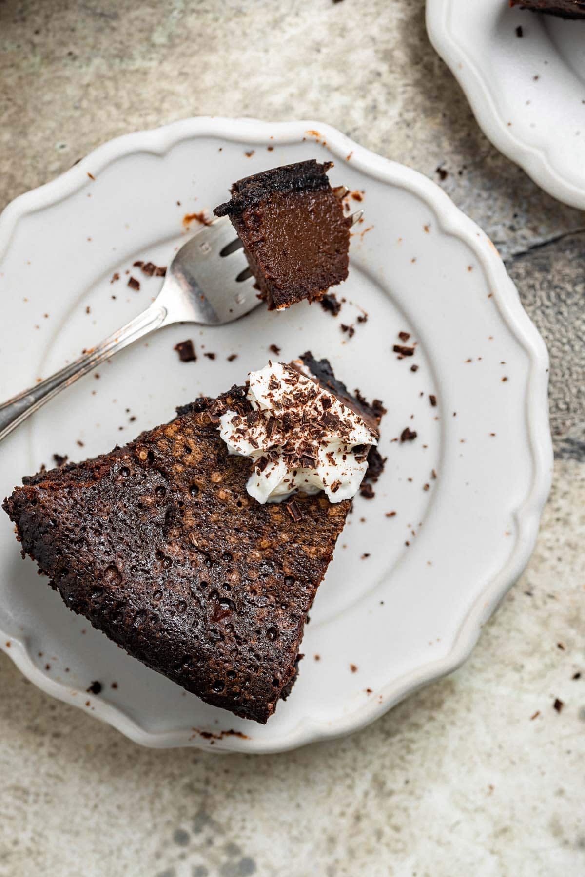 chocolate buttermilk pie on a plate with one forkful removed showing off the creamy filling