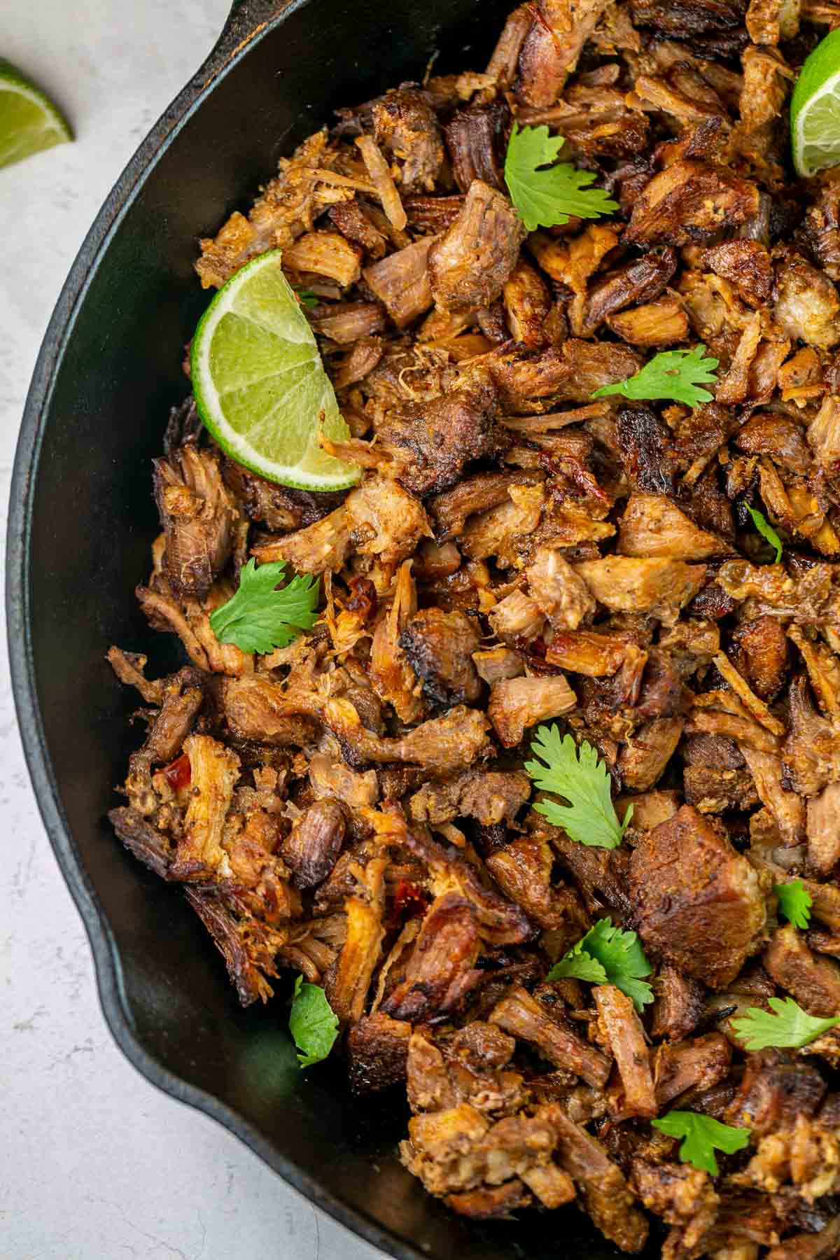 crispy shredded pork carnitas in a cast iron skillet