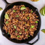 shredded pork shoulder carnitas in a cast iron skillet