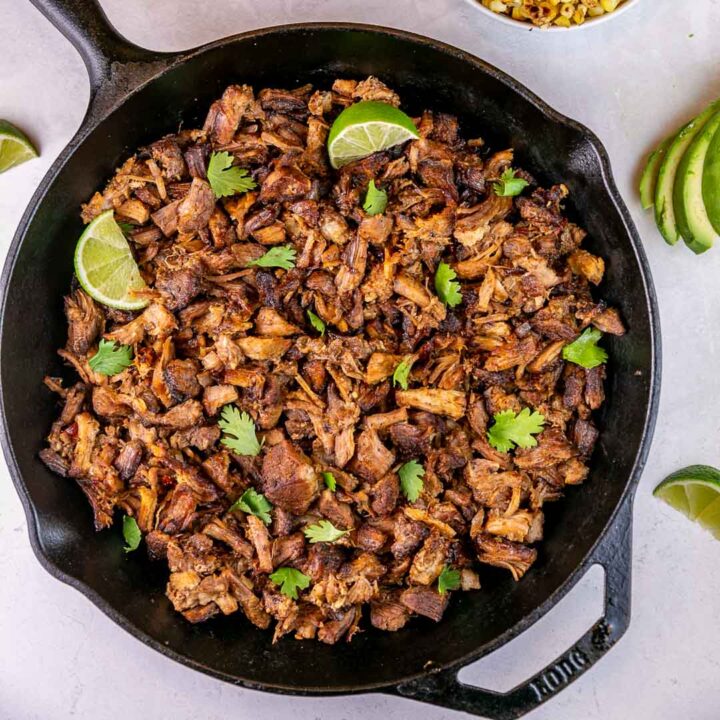 shredded pork shoulder carnitas in a cast iron skillet