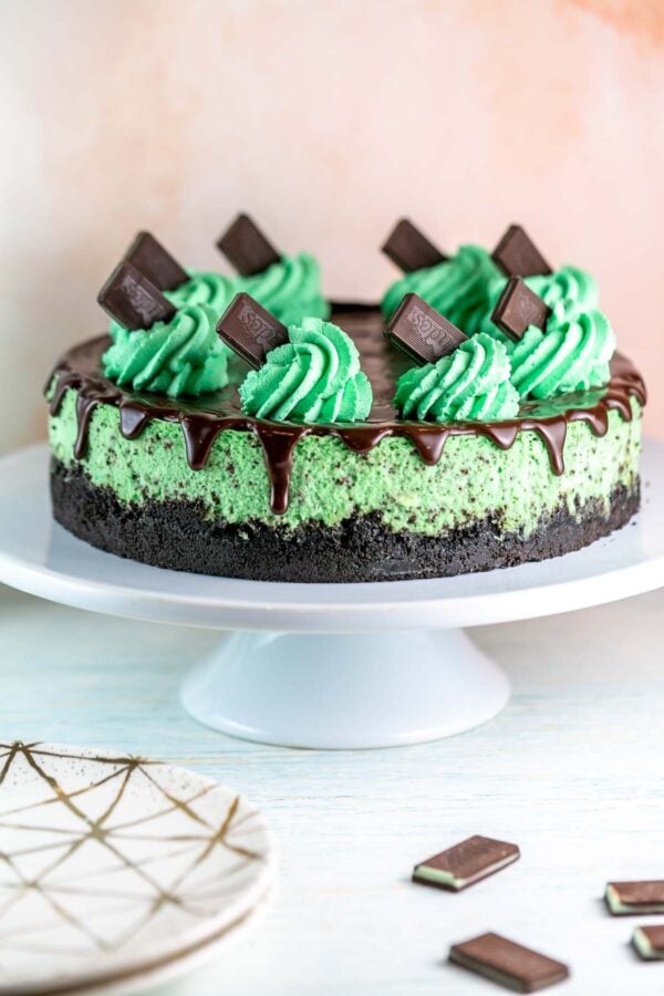 mint chocolate cheesecake with oreo crust on a white cake plate