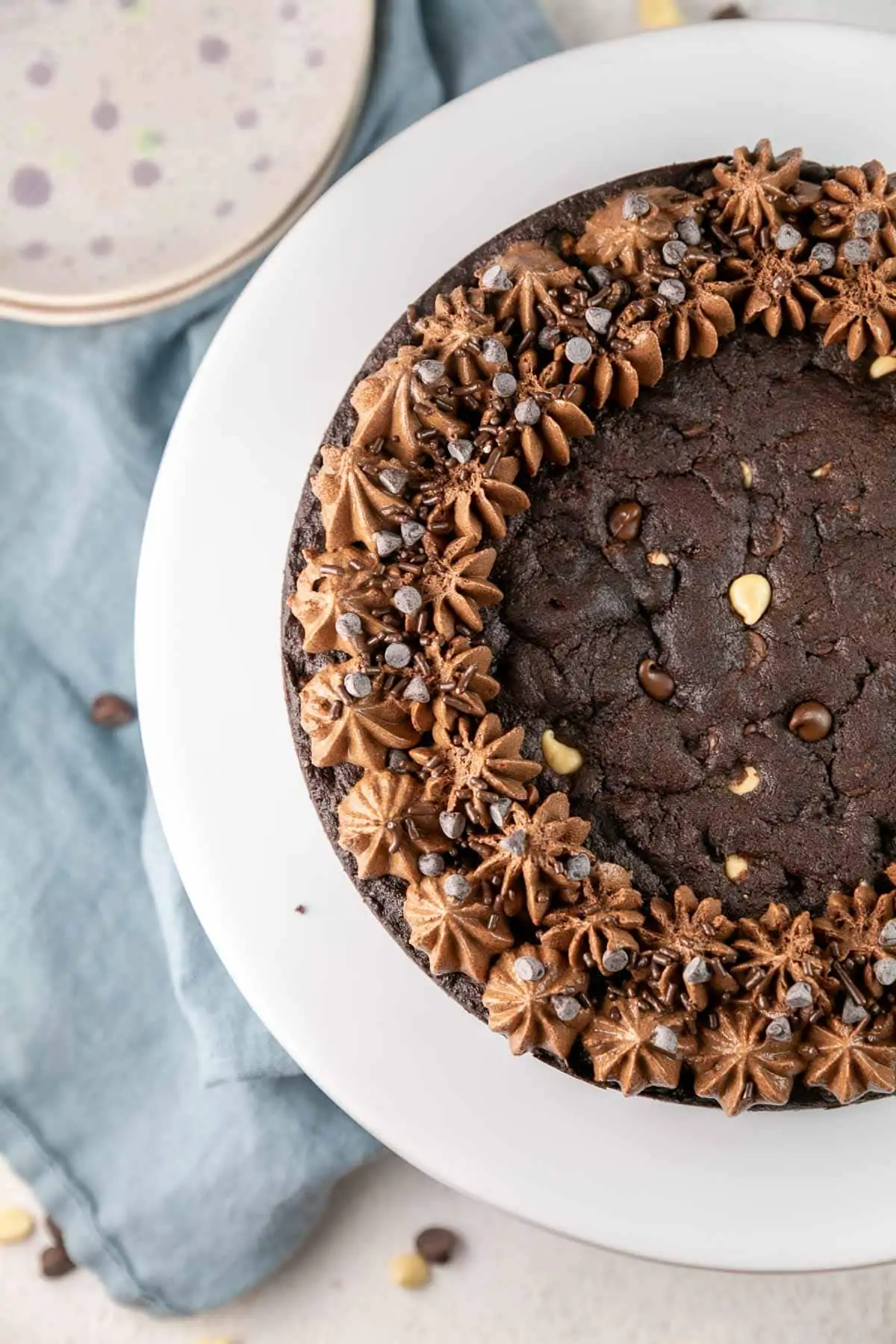 dark chocolatey cookie with dollops of decorative frosting on a white cake stand