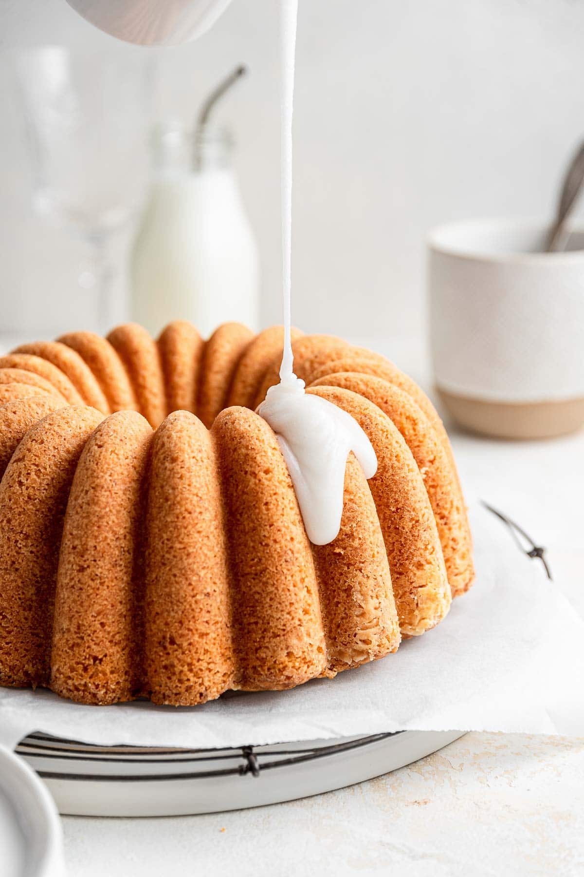 white coconut glaze pouring down onto a bundt cake