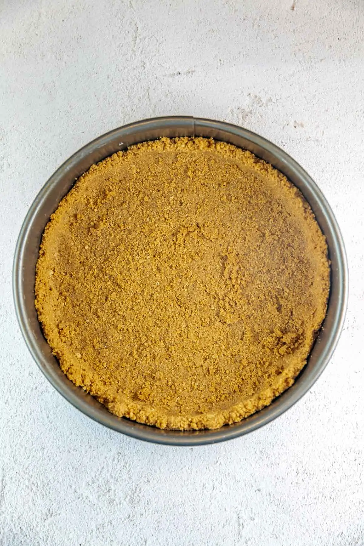 cookie crust made from nutter butters in a springform pan