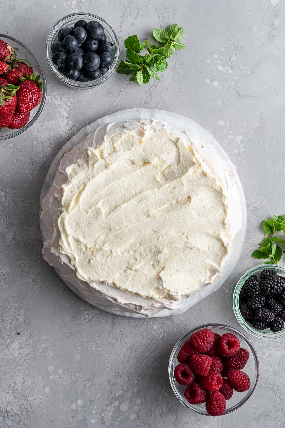 pavlova topped with a pile of fluffy lemon curd cream