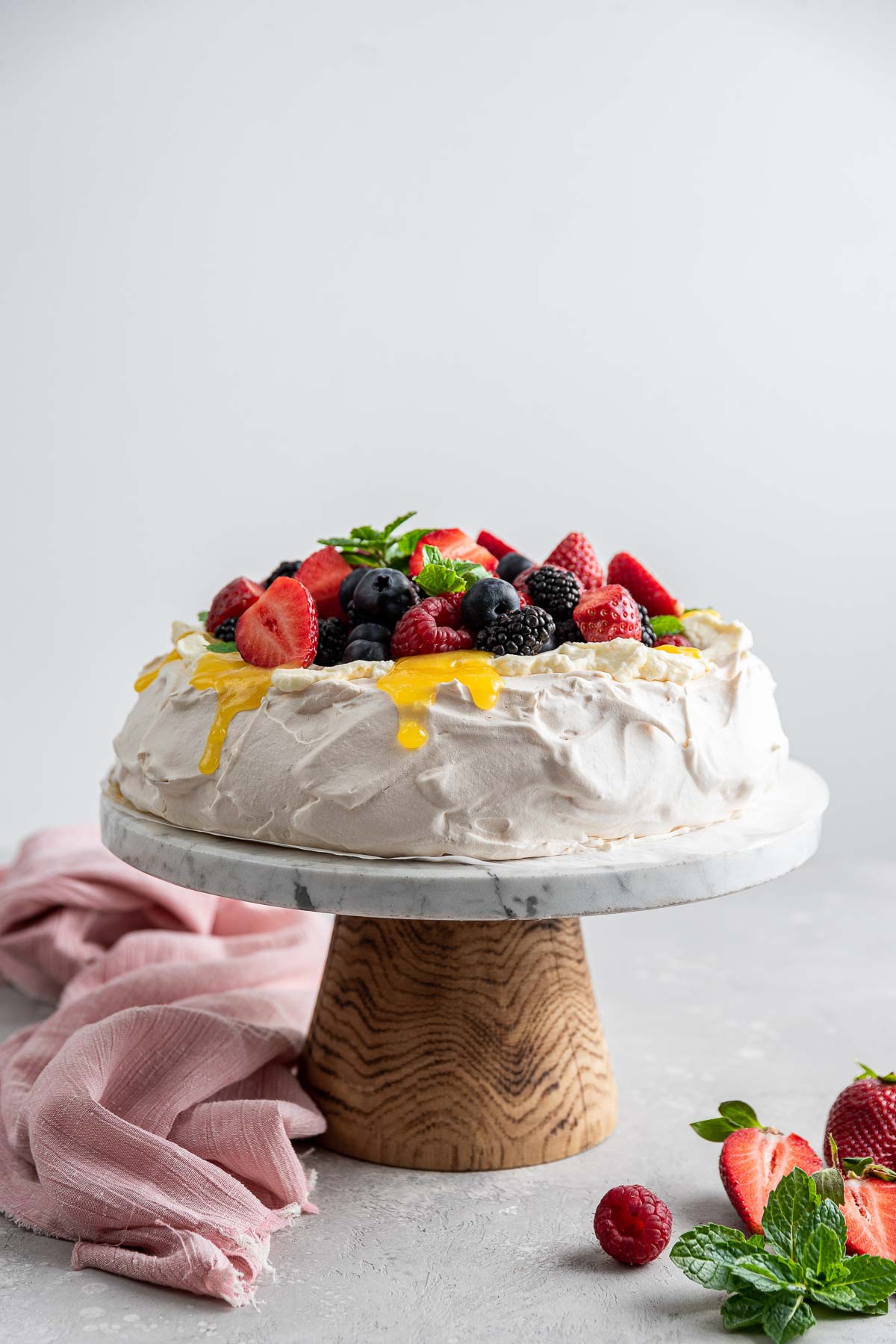 side view of a tall pavlova on a cake stand