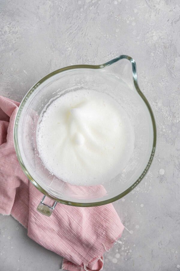 lightly whipped egg whites in a glass mixing bowl