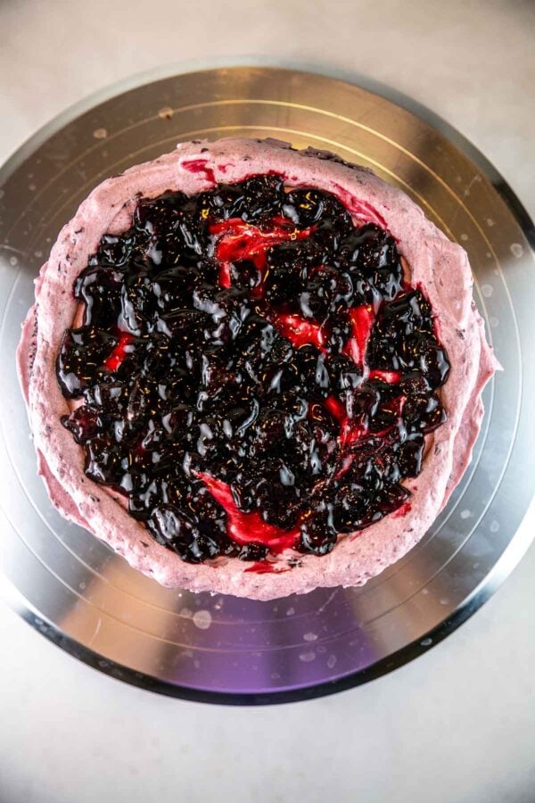 overhead view of a cake layer covered with buttercream and filled with cherries