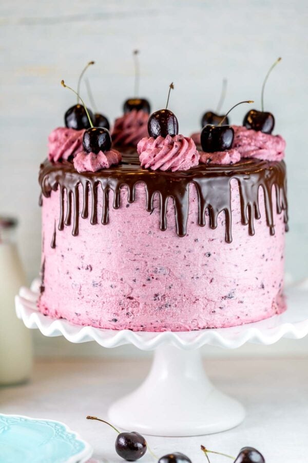 cake covered in pink cherry frosting with ganache drips running down the side