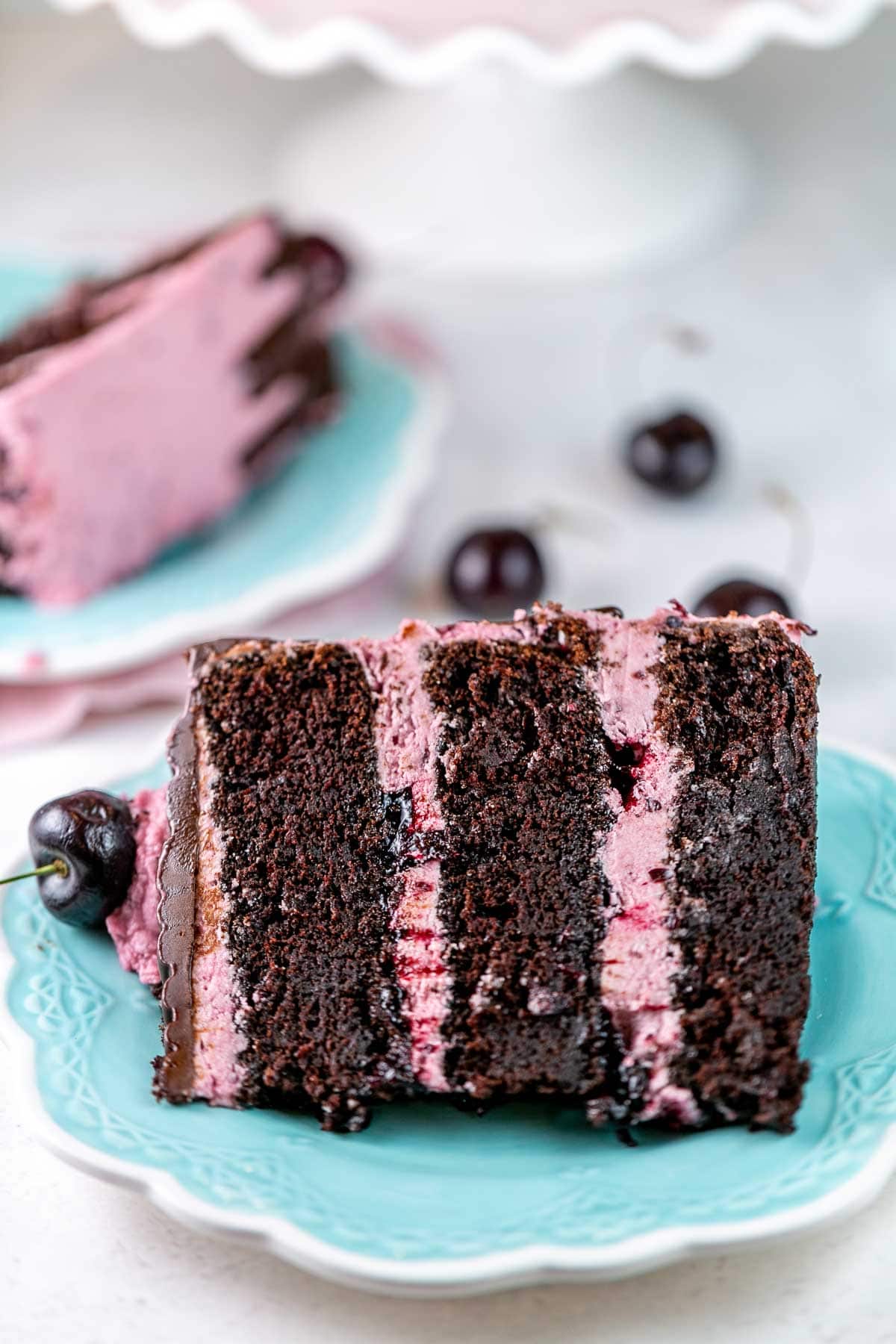 three layers of chocolate cake filled with cherries and pink cherry frosting