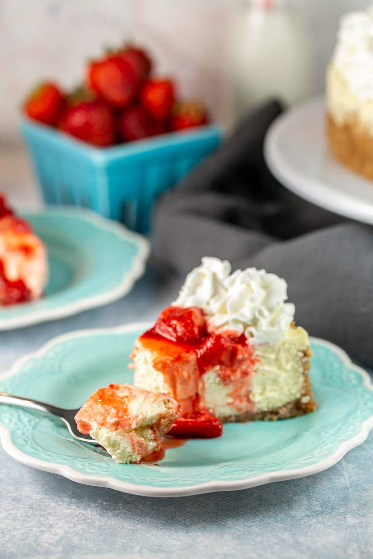 fork removing the end of a piece of strawberry cheesecake