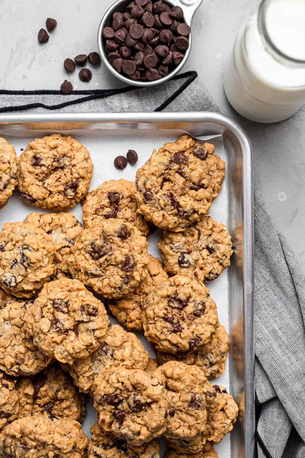 cookies piled onto a metal cookie sheet.