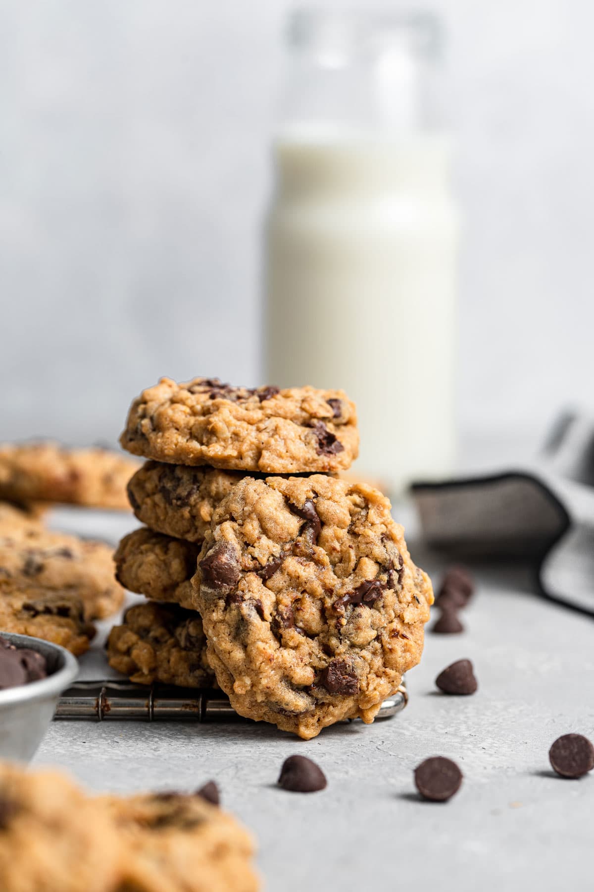 stack of cookies in front of a jug of milk.