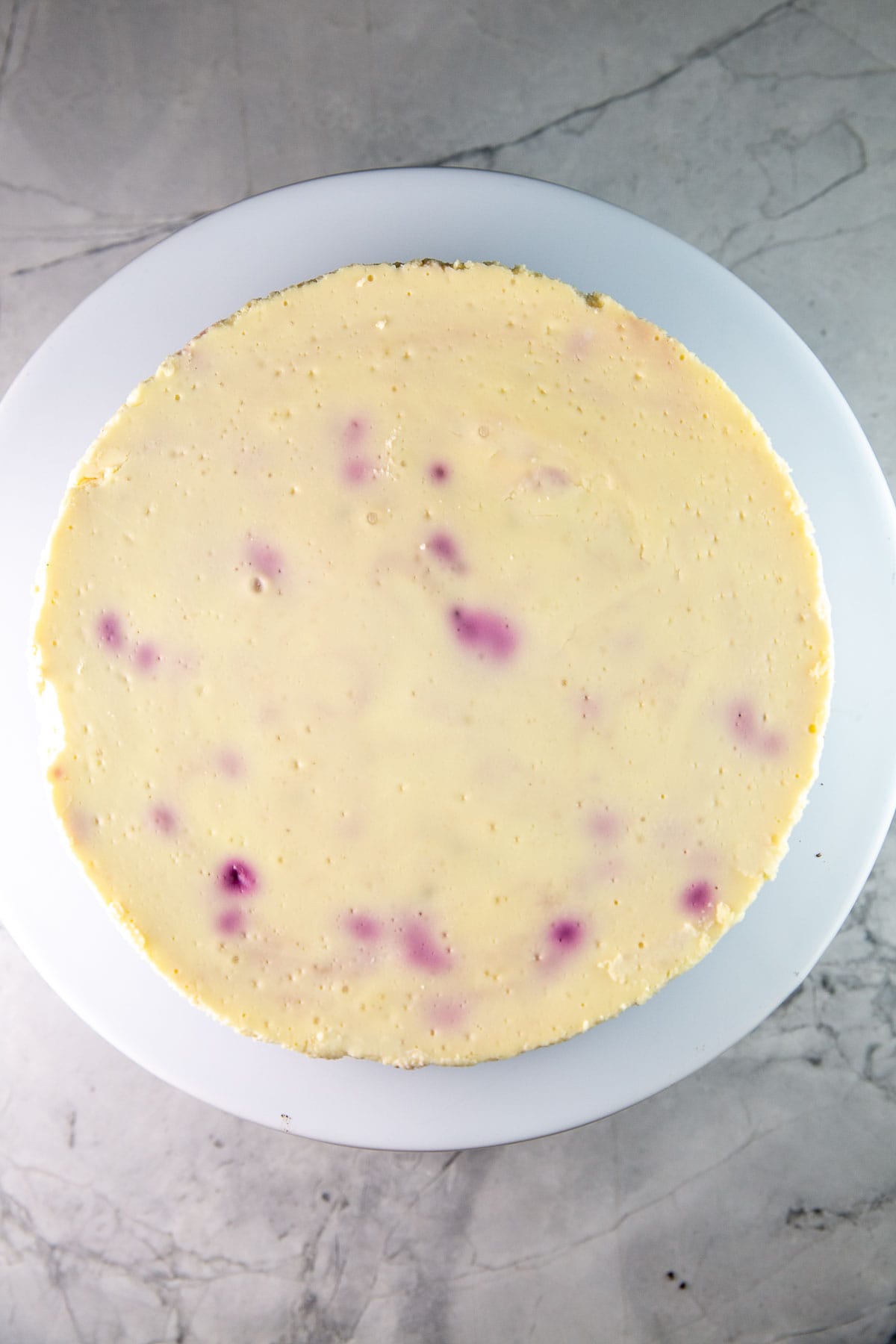 overhead view of cheesecake made with fresh cherries showing purple swirls in the batter